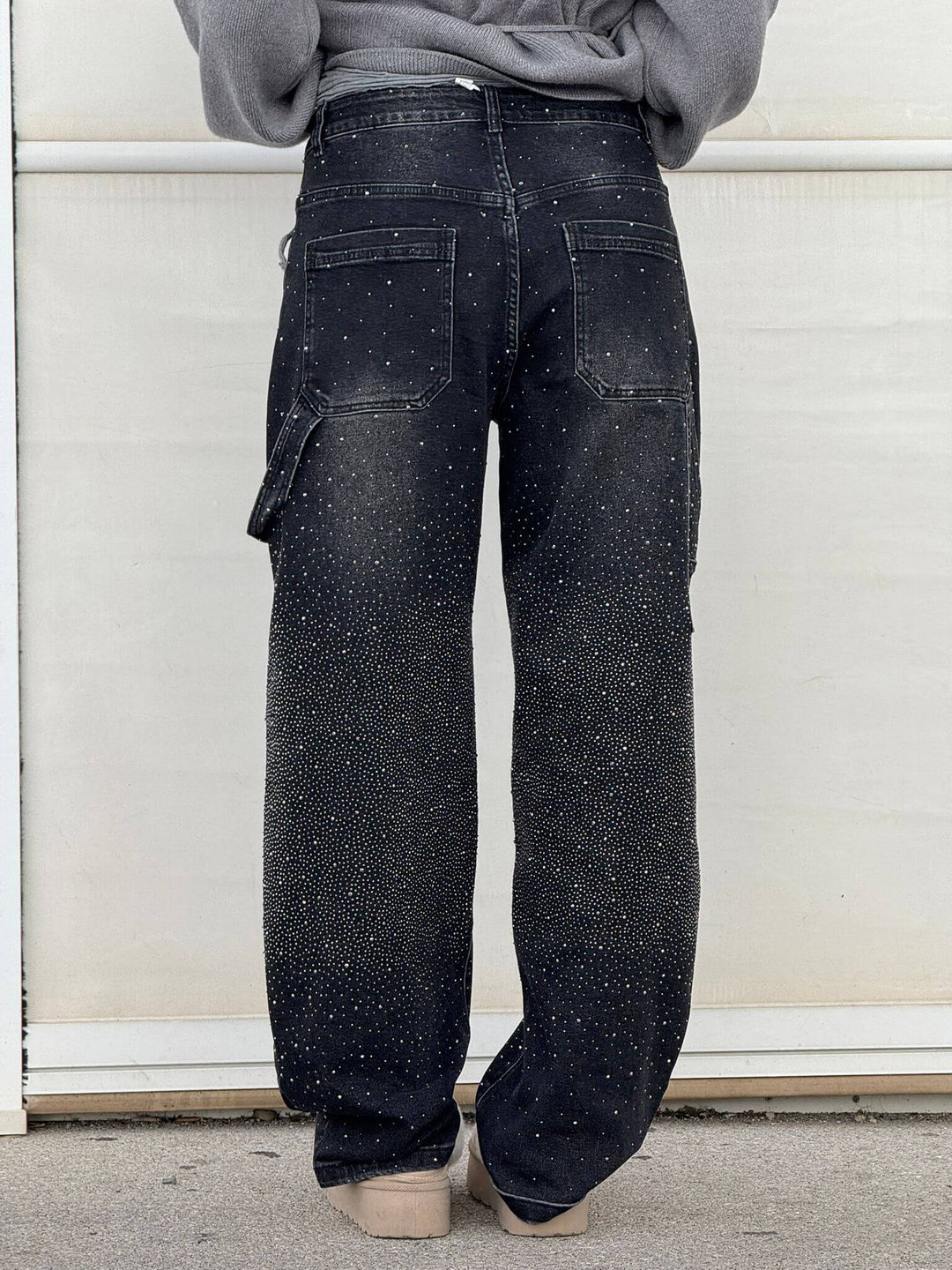 Woman seated wearing comfortable high-waist straight leg vintage denim jeans with crystal details.