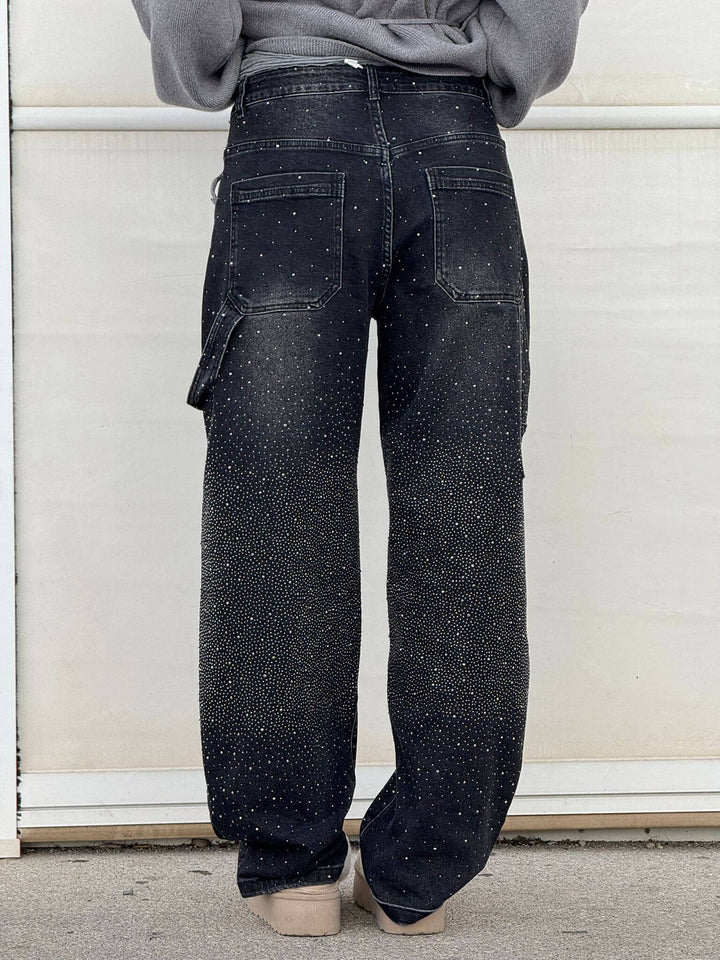 Woman seated wearing comfortable high-waist straight leg vintage denim jeans with crystal details.