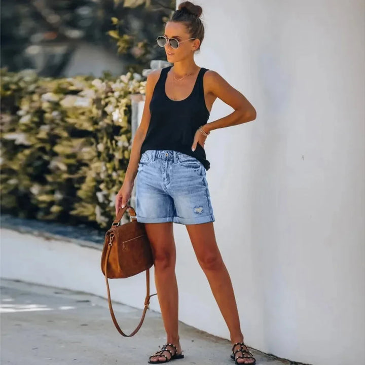 Women's high-waisted distressed light wash denim shorts with a stylish rolled hem, perfect for casual summer wear.