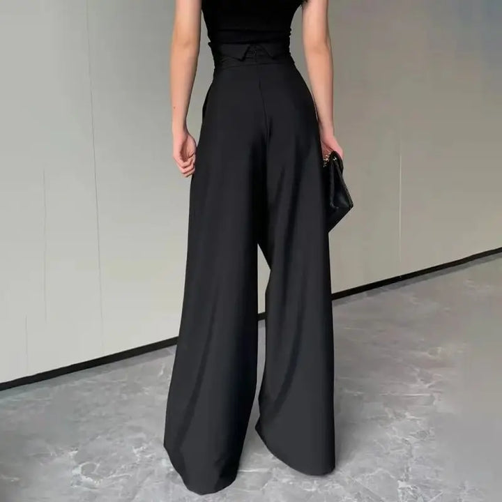 Elegant women's pleated wide-leg trousers, high-waisted with crossed detail, ideal for spring/summer fashion.