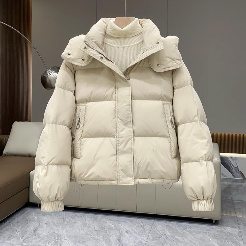 Sleek women's hooded puffer jacket, high neck, perfect for a chic & warm winter outfit.