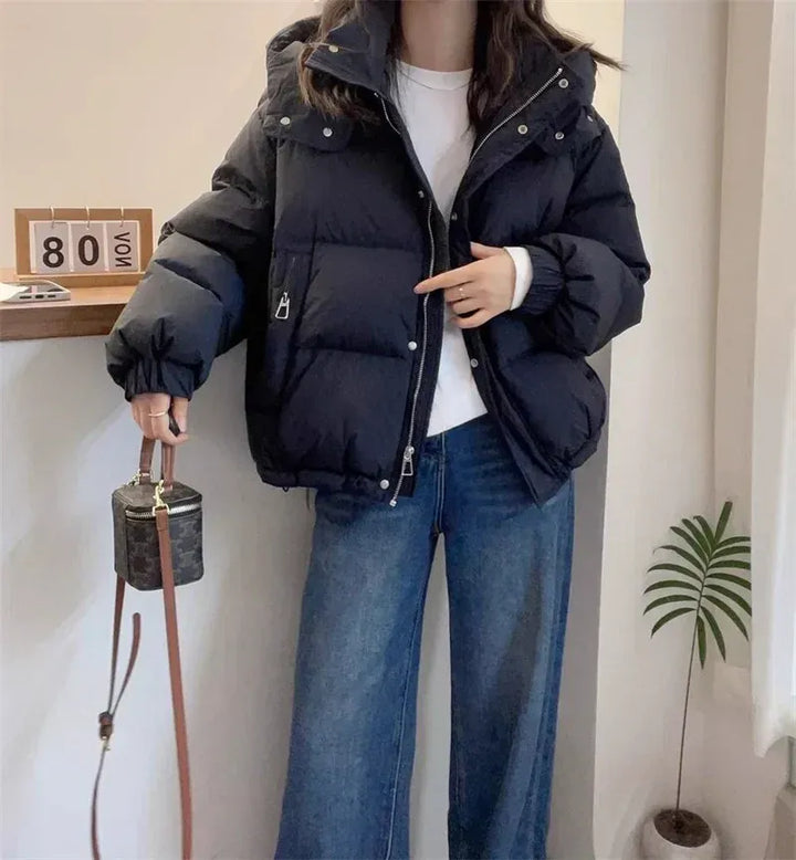 Warm & cozy women's puffer coat, hooded with a high neck, essential winter apparel.