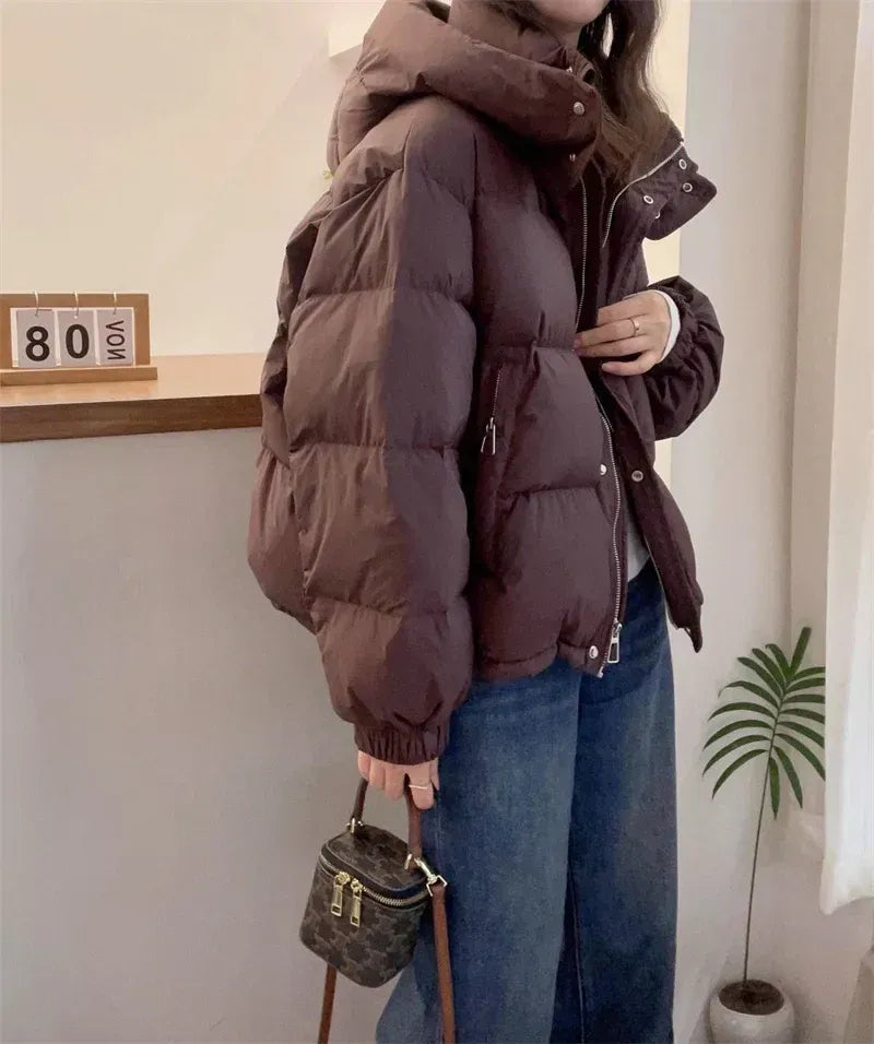 Modern women's puffer coat, high neck & hood, a stylish statement for winter fashion.