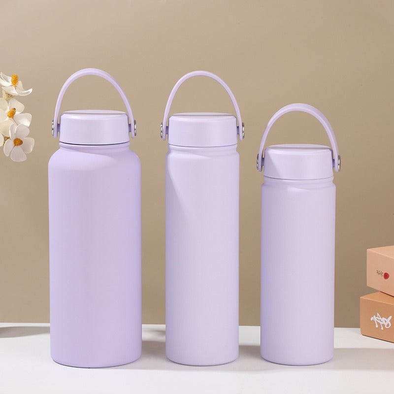 Women's insulated stainless steel water bottle, leak-proof, ergonomic handle, keeps hot/cold for active use.