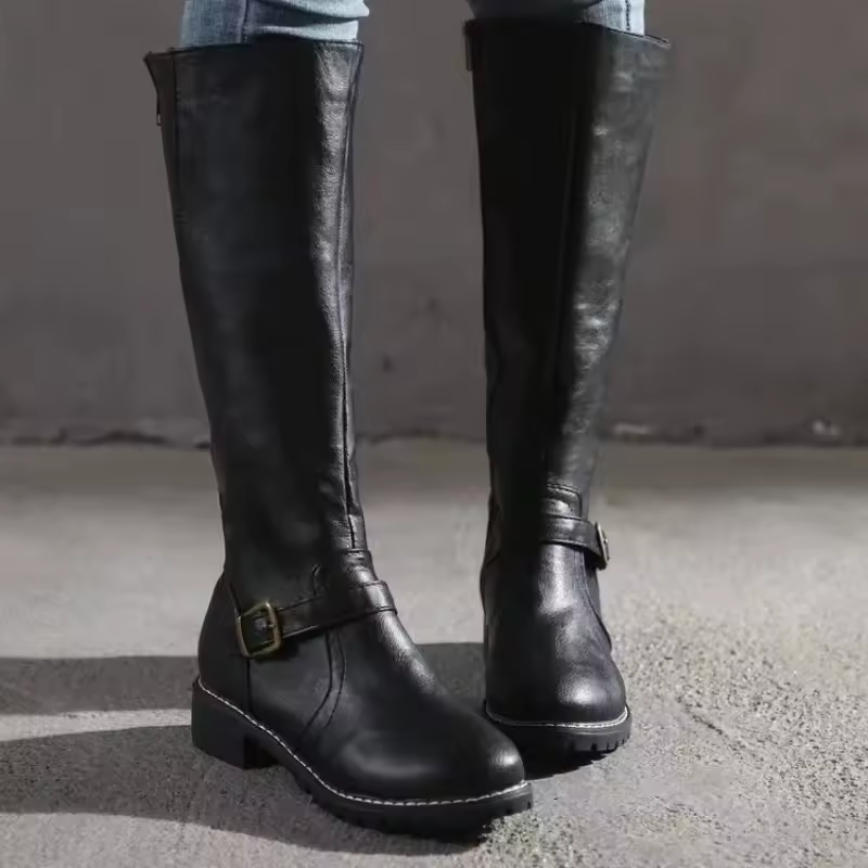 Sleek women's knee-high boots, flat heel design, finished with decorative side buckle straps.