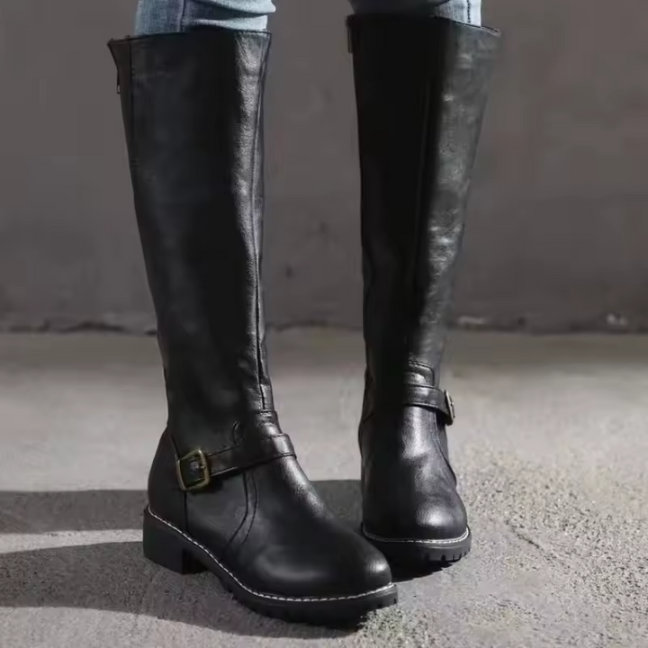 Sleek women's knee-high boots, flat heel design, finished with decorative side buckle straps.