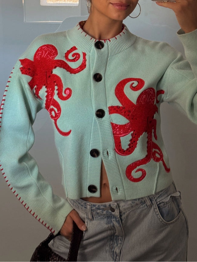 Close-up of a women's octopus pattern knit cardigan, showing detailed graphic and button front.