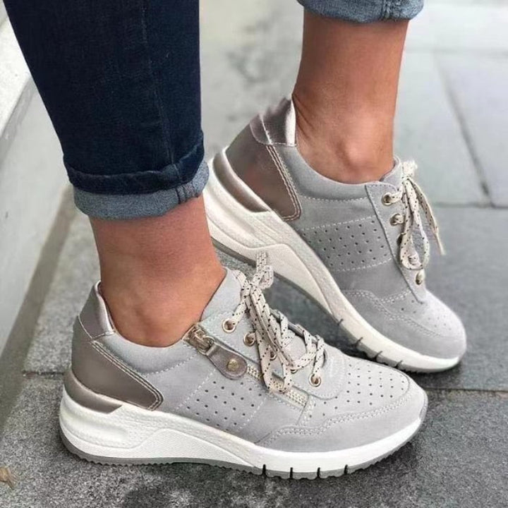 Lace-up women's walking shoes with a wedge platform, side zip detail, and perforated upper for style.