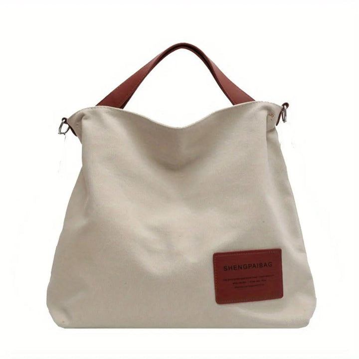 Women's large slouchy canvas tote bag in black with adjustable strap, perfect for everyday use or travel.