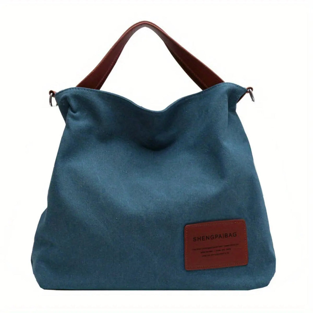 Minimalist black slouchy canvas tote bag for women. A chic, large shoulder or crossbody bag for modern casual outfits.