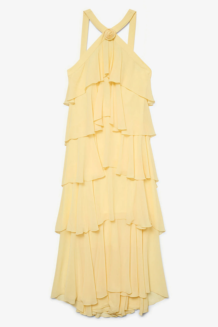Vibrant yellow layered maxi dress with halter neck & floral rosette, a stunning choice for summer special occasions.