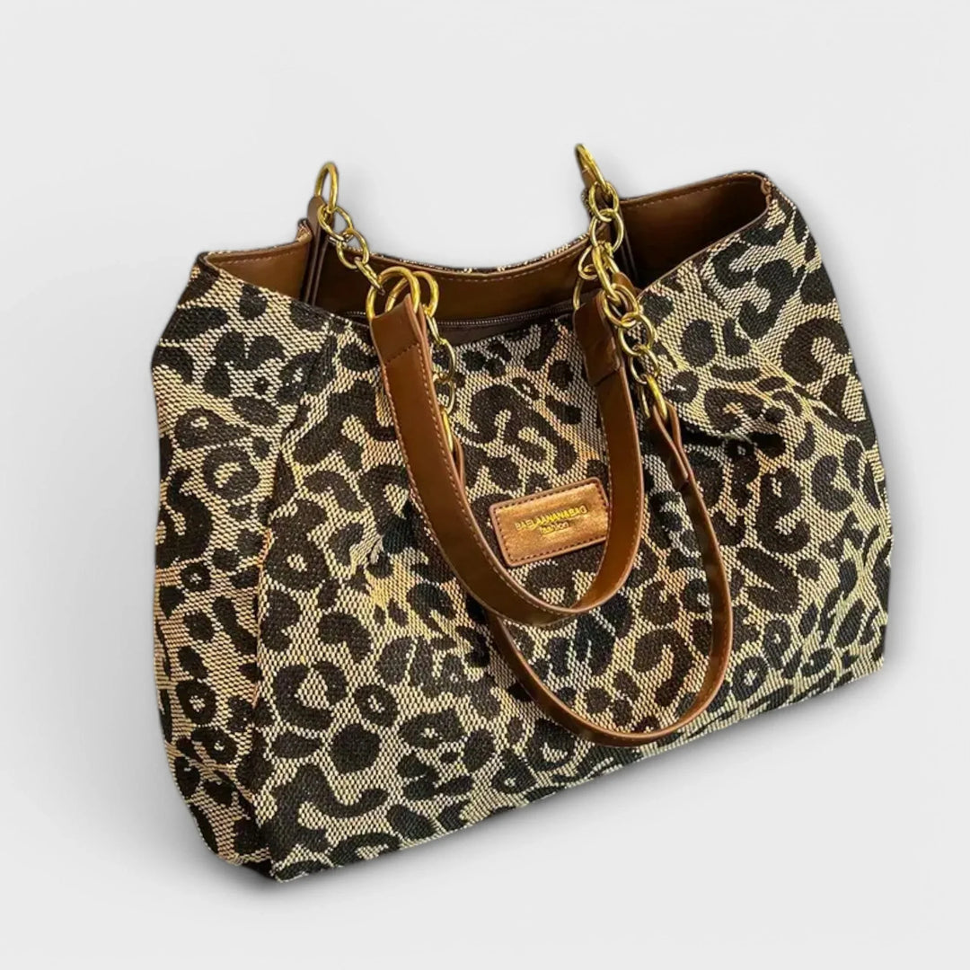 Women's leopard print shoulder bag with stylish faux-leather handles. Trendy animal print handbag for everyday fashion.