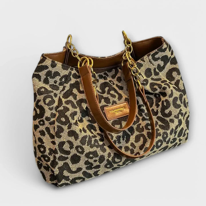 Women's leopard print shoulder bag with stylish faux-leather handles. Trendy animal print handbag for everyday fashion.