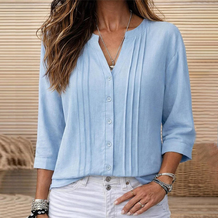 Women's light blue pleated blouse with button front & 3/4 sleeves. Chic & versatile top for office or casual wear.