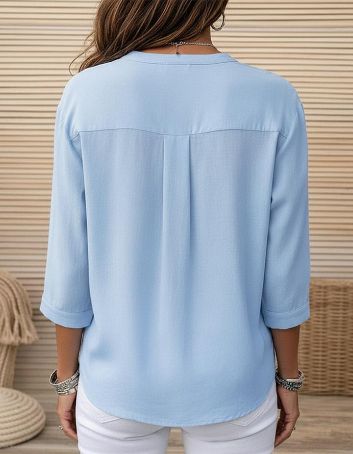 Stylish women's light blue blouse featuring pleats & a button front. Versatile 3/4 sleeve top for any occasion.