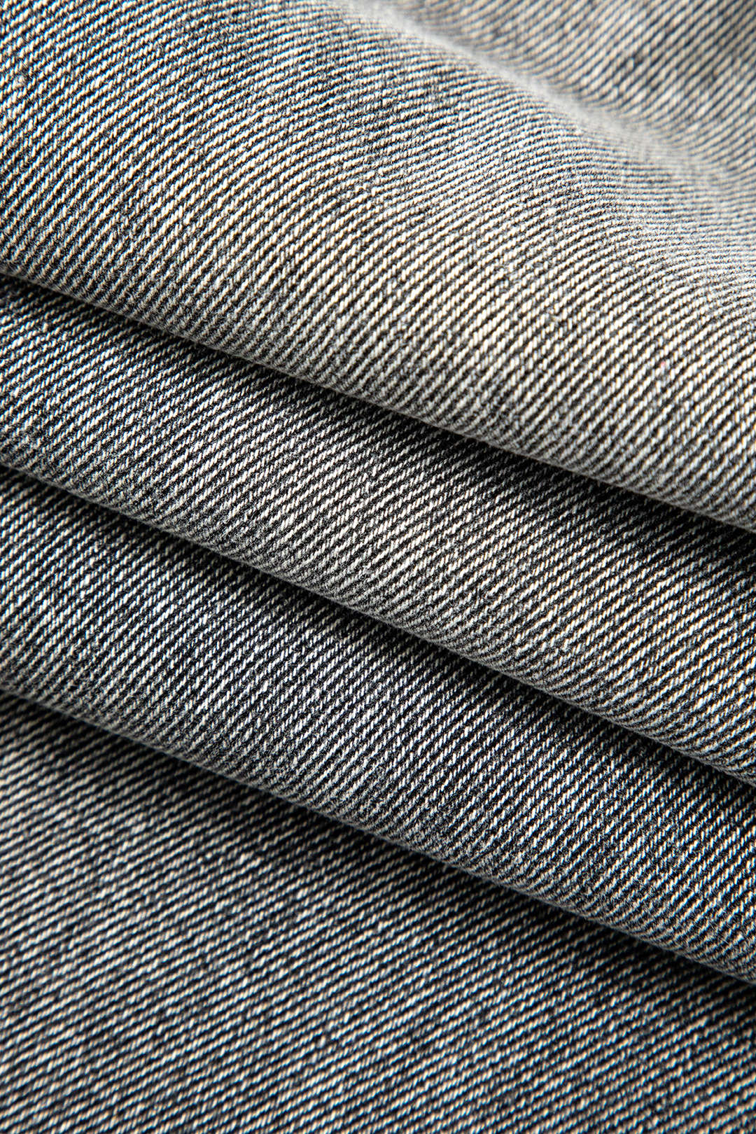Detail of fabric on women's unique asymmetric high-waist straight leg jeans, showing quality and texture.