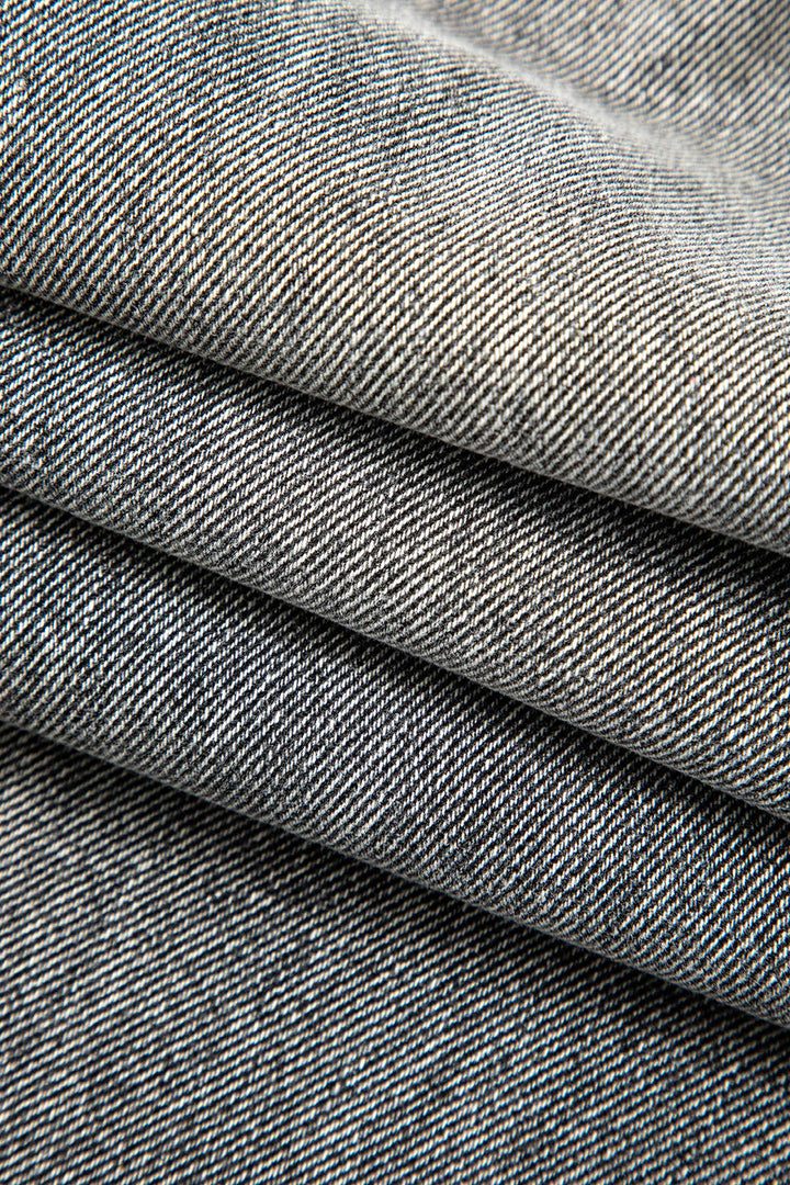 Detail of fabric on women's unique asymmetric high-waist straight leg jeans, showing quality and texture.