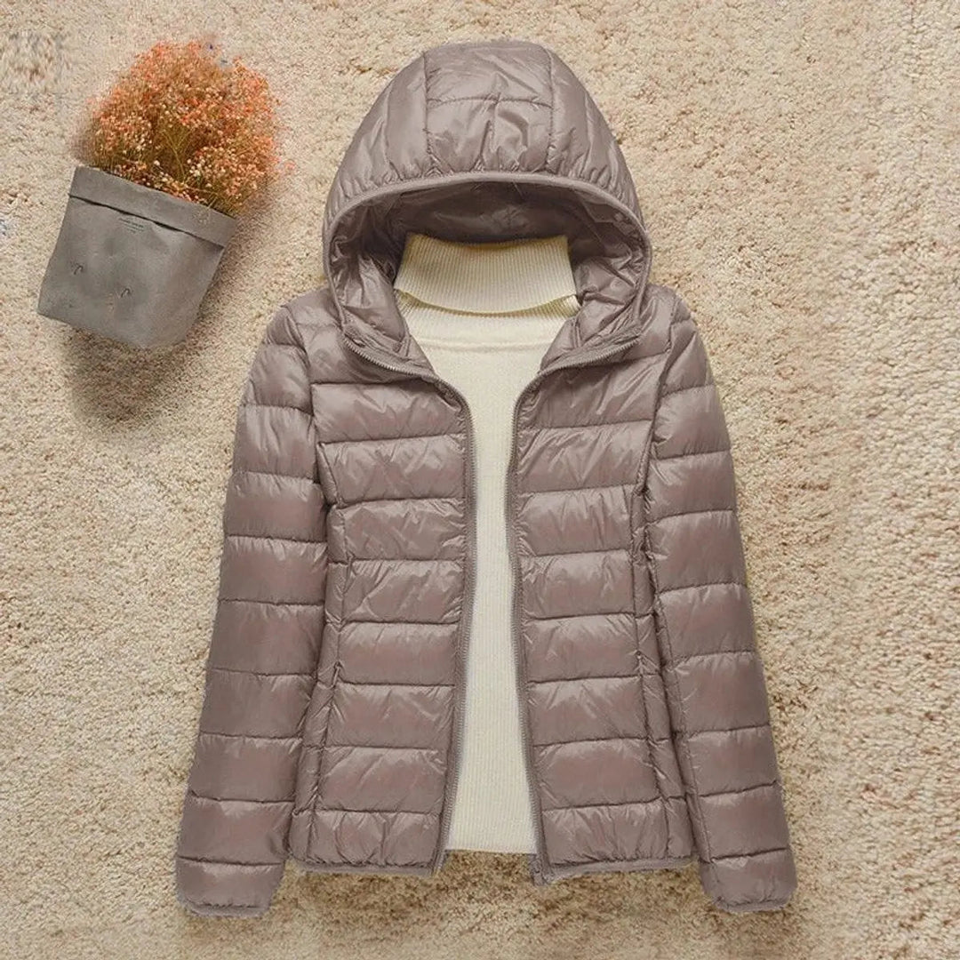 Women's lightweight hooded quilted puffer jacket, packable for travel and warmth in autumn/winter.