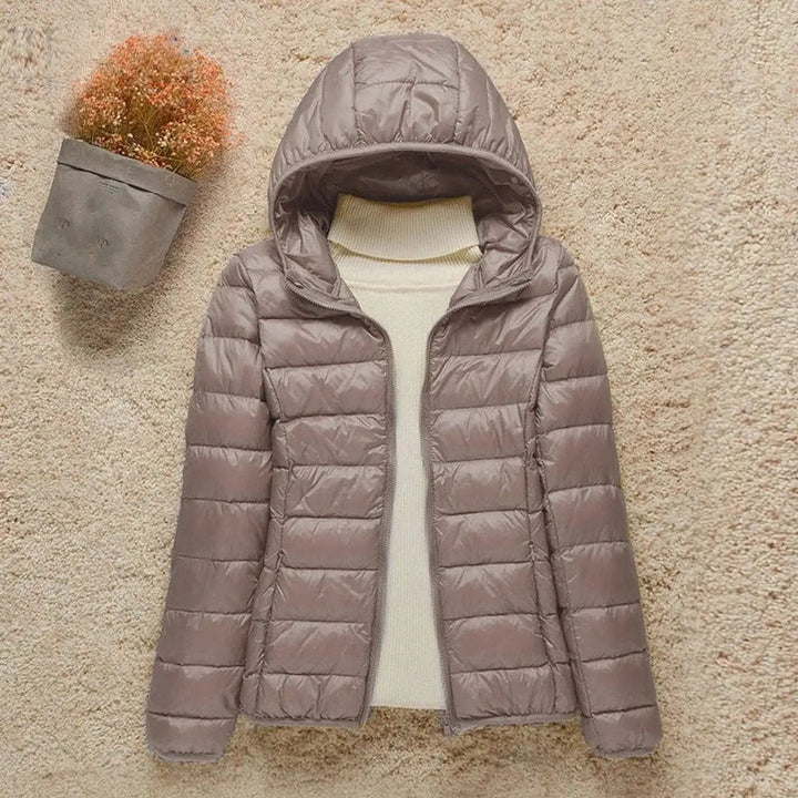 Women's lightweight hooded quilted puffer jacket, packable for travel and warmth in autumn/winter.