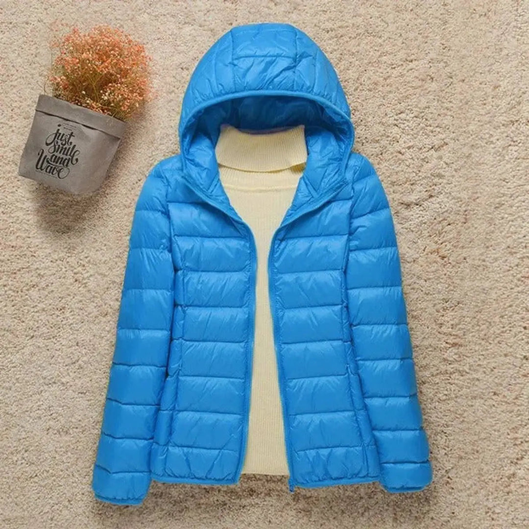 Packable women's hooded quilted puffer jacket. Ideal lightweight travel outerwear for warmth & easy storage.