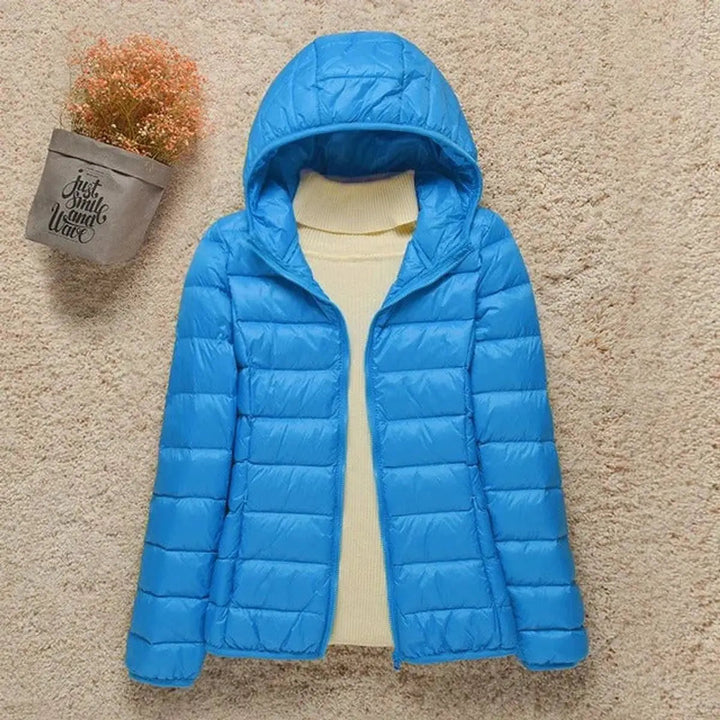 Packable women's hooded quilted puffer jacket. Ideal lightweight travel outerwear for warmth & easy storage.