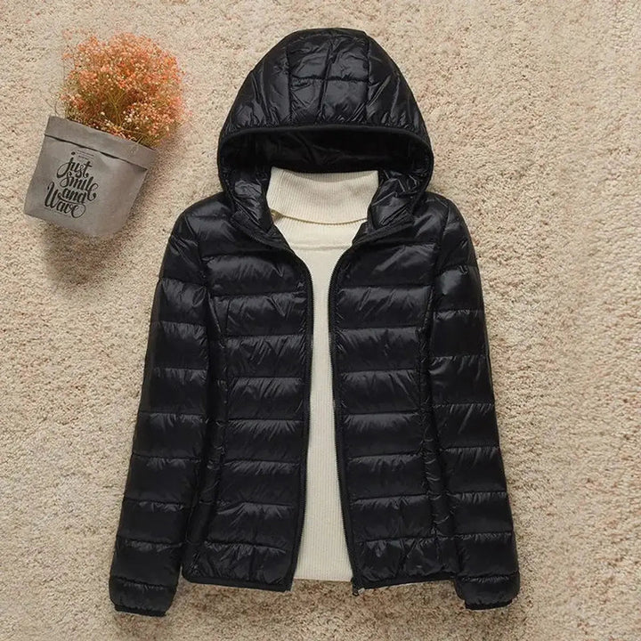 Warm women's quilted puffer jacket with hood. Stylish, lightweight, perfect for casual activewear in cold.