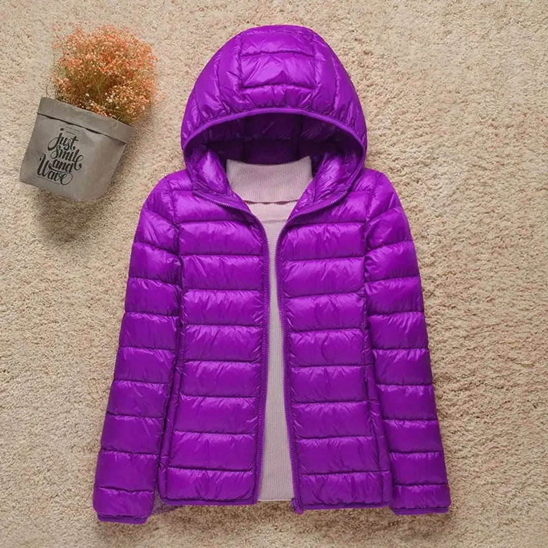 Fashionable women's insulated quilted puffer with hood. Lightweight & packable for versatile outerwear.