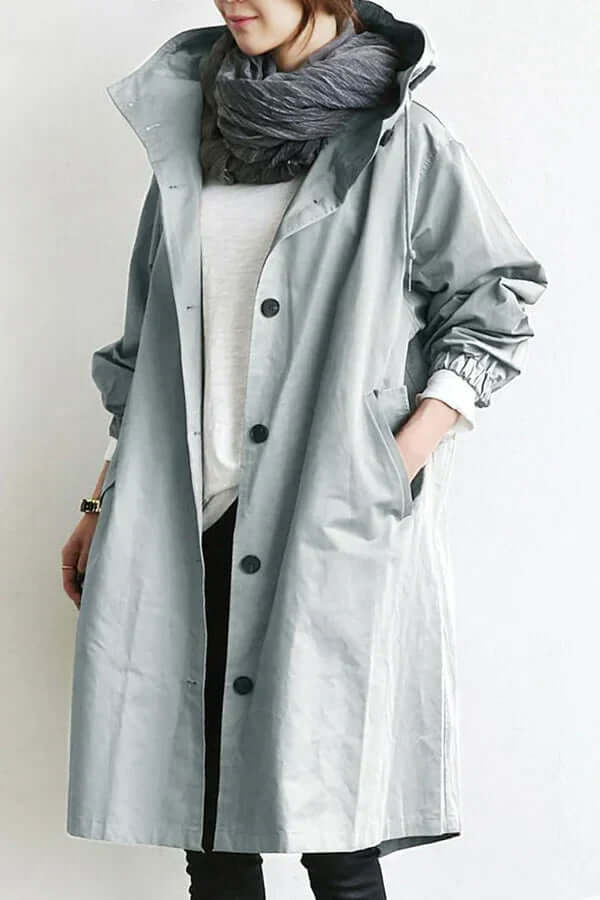 Woman wearing a lightweight waterproof rain cape, ready for outdoor adventure & rain protection.
