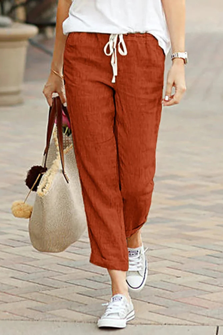 Model wearing stylish women's cropped linen trousers with drawstring waist, showcasing a relaxed fit & style.