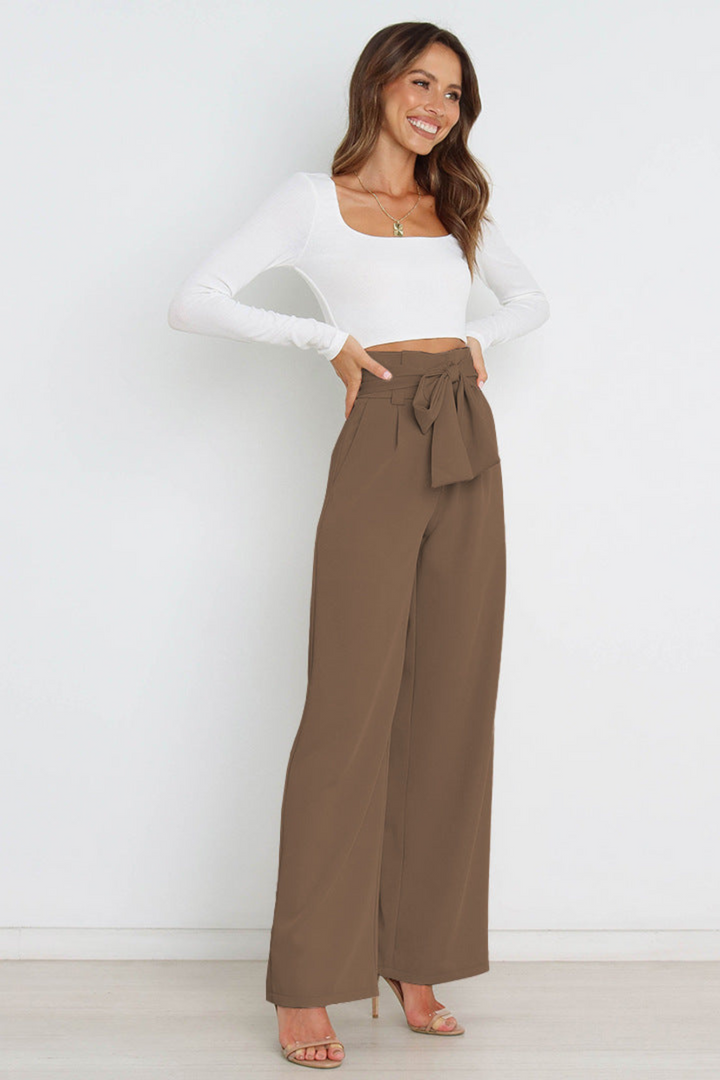 Women's high waist linen trousers with a relaxed wide leg and tie detail.
