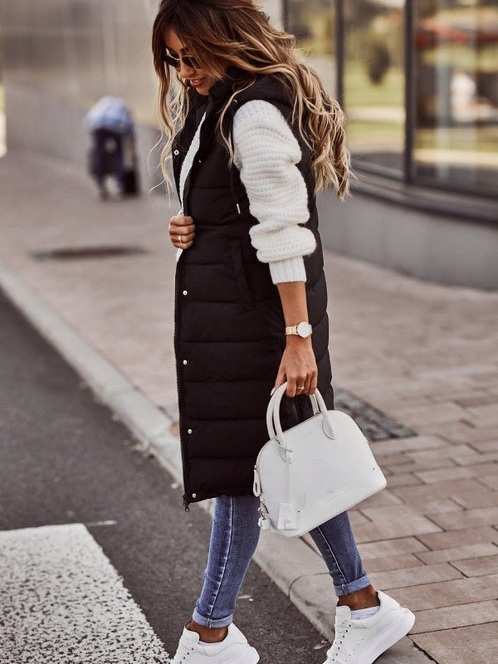 Stylish women's long hooded puffer vest. Perfect fall outerwear, a versatile layering piece for cozy fashion.
