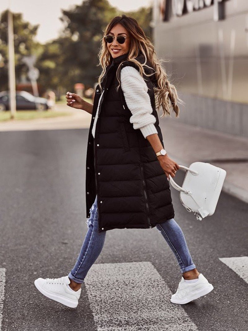 Quilted long hooded puffer vest for women. Sleeveless jacket, perfect for cold weather layering. Stylish & warm.