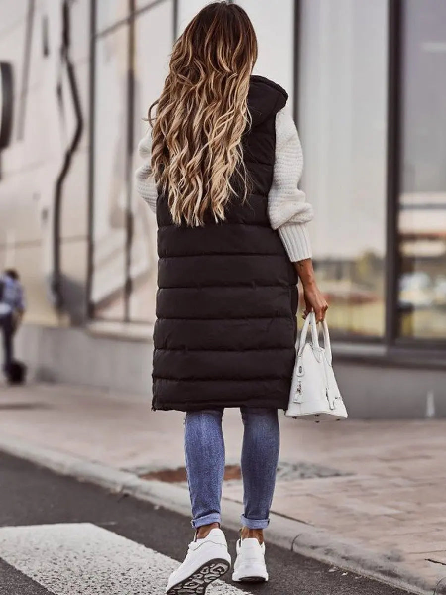 Versatile women's long hooded puffer vest, quilted sleeveless, a chic layering piece for fall & winter outfits.