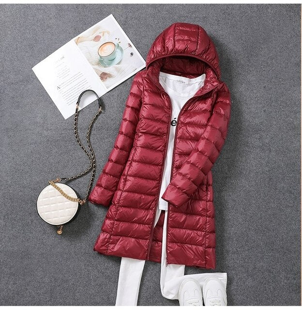 Women's long packable down jacket with detachable hood, ideal for winter warmth.