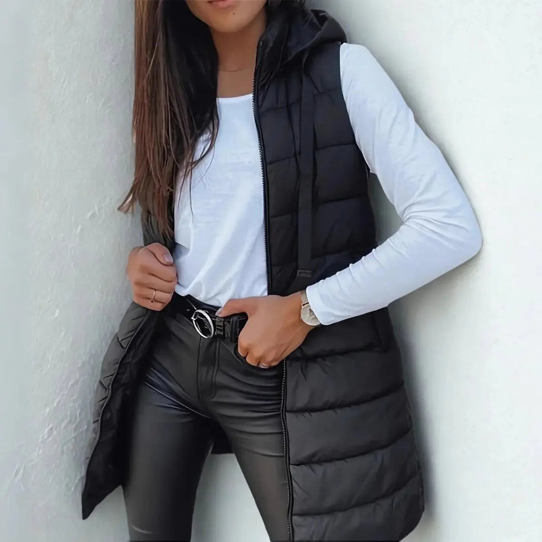 Women's longline hooded puffer vest in black, lightweight & stylish for fall/winter layering.