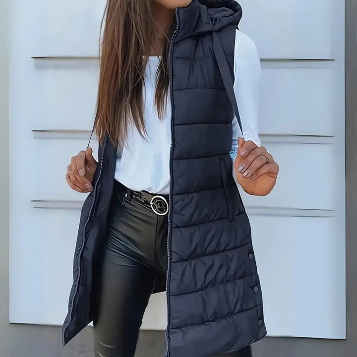 Casual women's longline hooded puffer vest, showing flattering extended length & cozy hood for versatile style.
