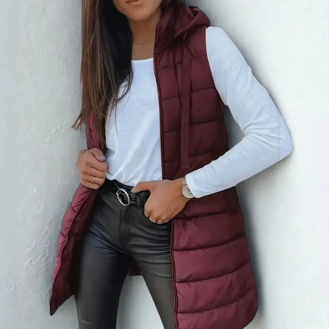 Chic women's longline sleeveless jacket, a hooded puffer vest perfect for casual winter fashion & warmth.