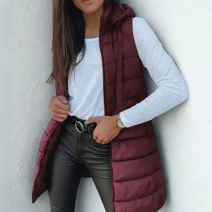 Chic women's longline sleeveless jacket, a hooded puffer vest perfect for casual winter fashion & warmth.