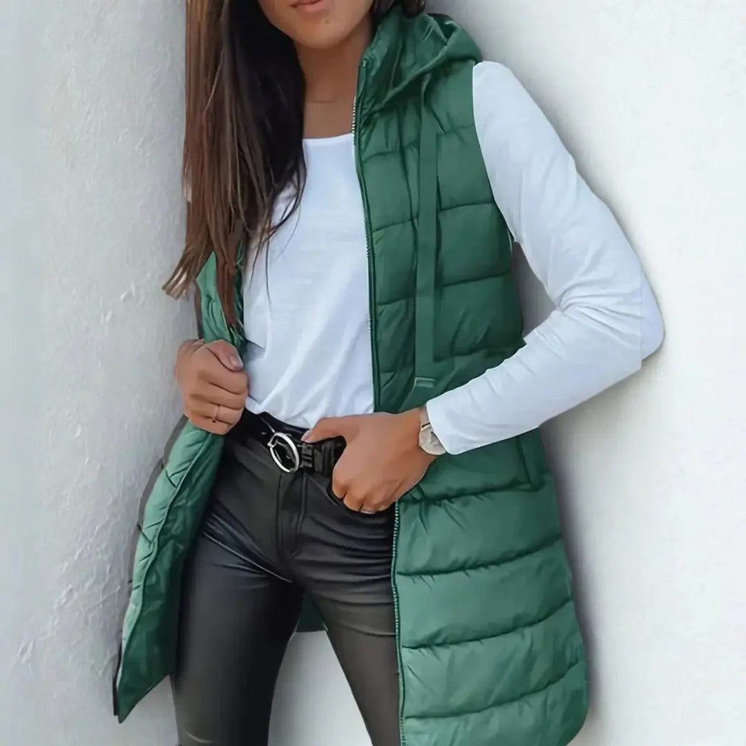 Comfortable women's longline hooded puffer vest, available in various sizes, ideal for layering & casual style.