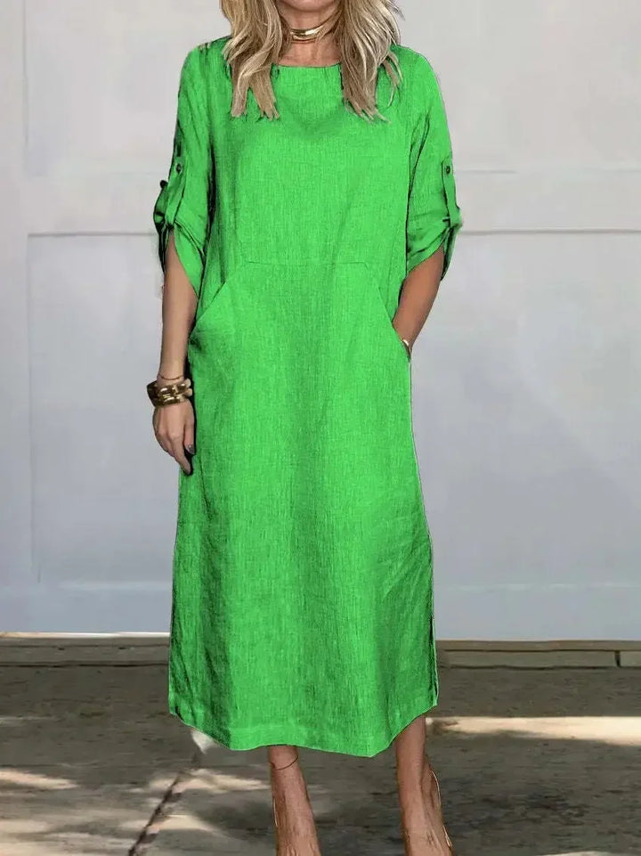 Casual women's A-line midi dress, featuring a comfortable design, roll-tab sleeves, and practical pockets.