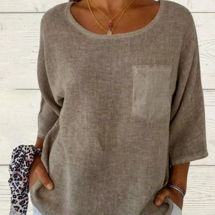 Women's loose fit casual top with round neck, short sleeves, & chest pocket. Perfect for comfortable everyday wear.