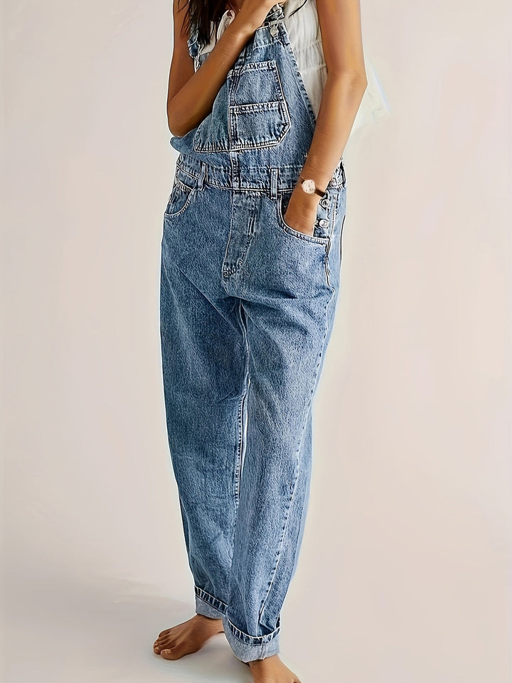 Light blue women's denim dungarees, loose fit casual overall. Adjustable straps ensure comfort and style.