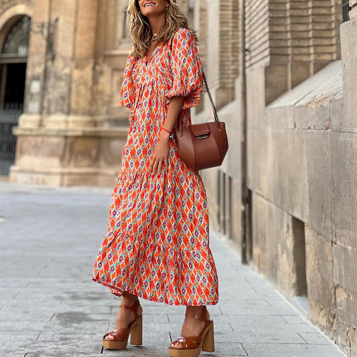 Knee-length women's dress featuring a unique print, loose fit, and stylish ruffled hem.