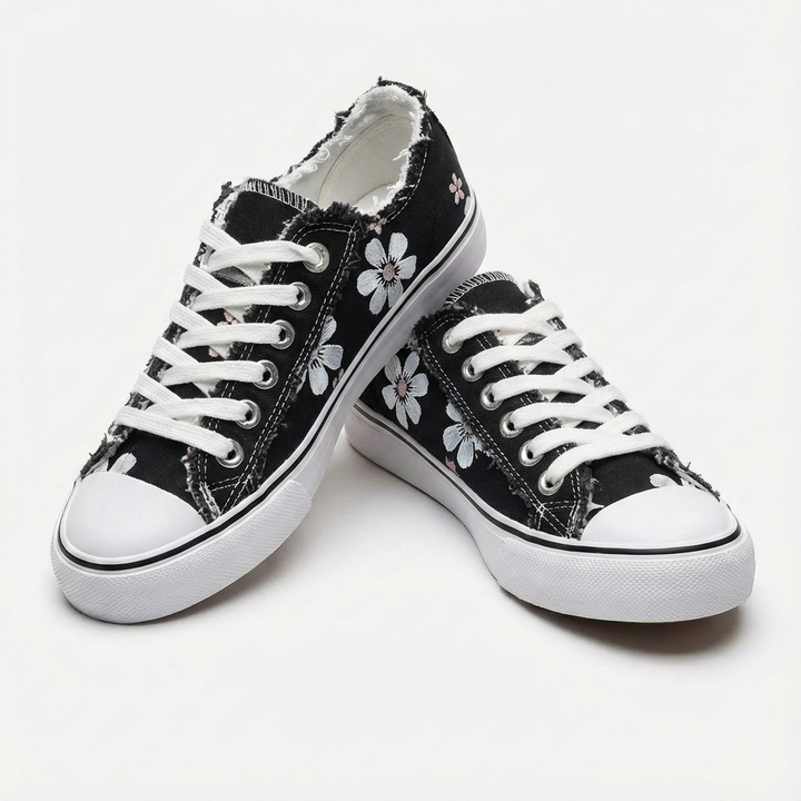 Lace-up women's sneakers, stylish with intricate floral embroidery & modern frayed detailing.