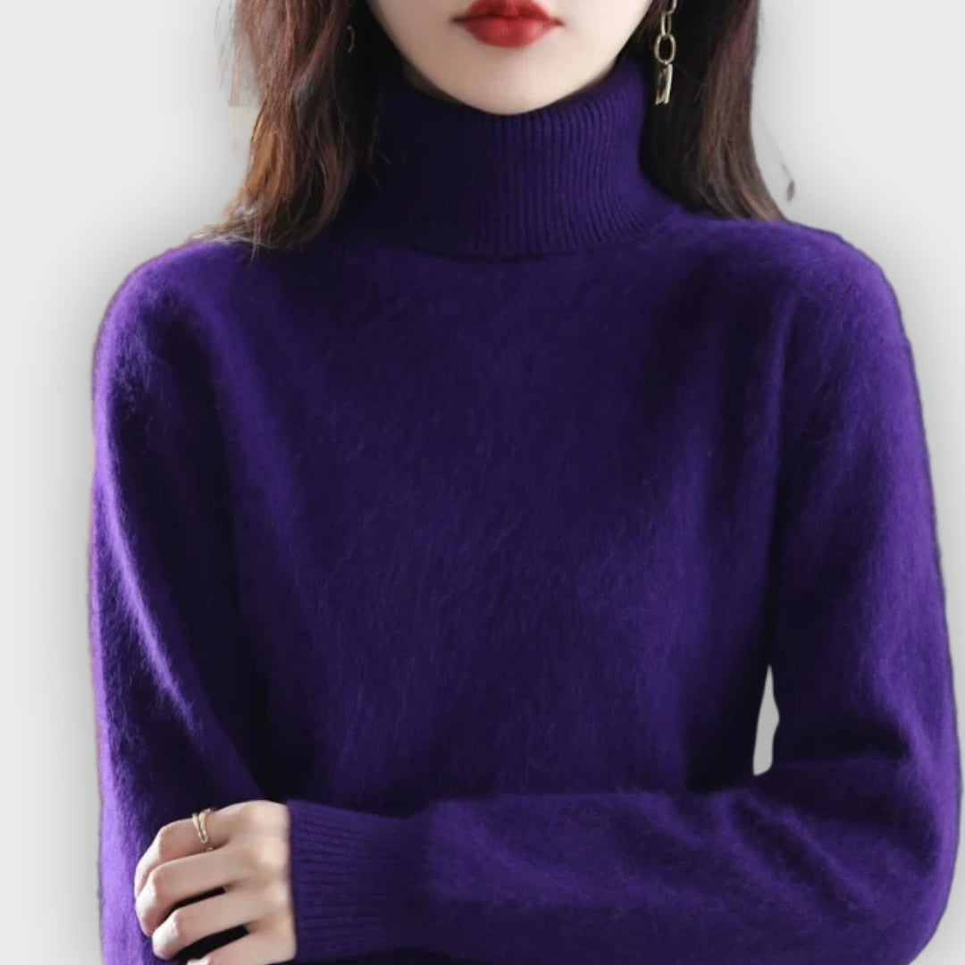 A warm and elegant women's cashmere turtleneck sweater in a beautiful cream color.