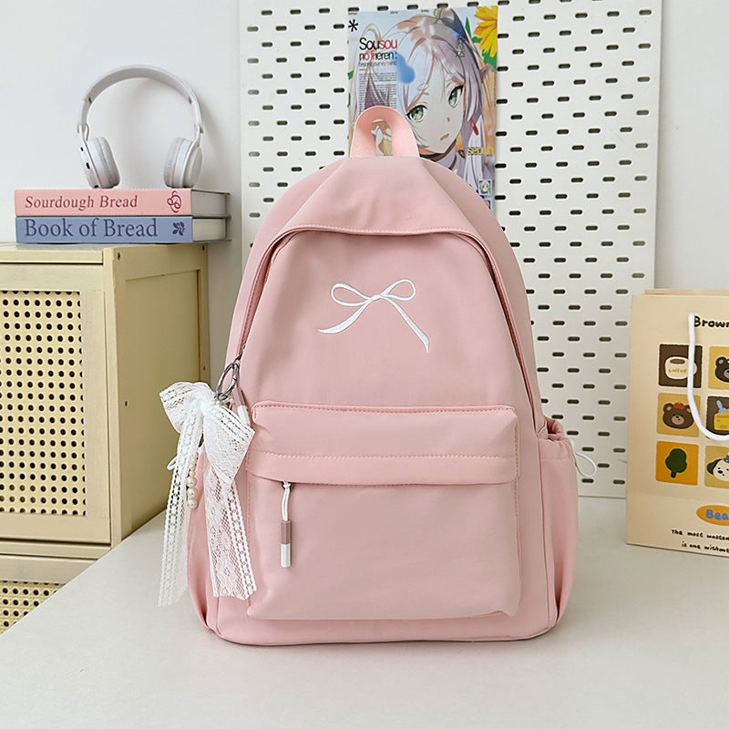 Women's minimalist school backpack with a chic bow embellishment. Perfect for students & daily carry.