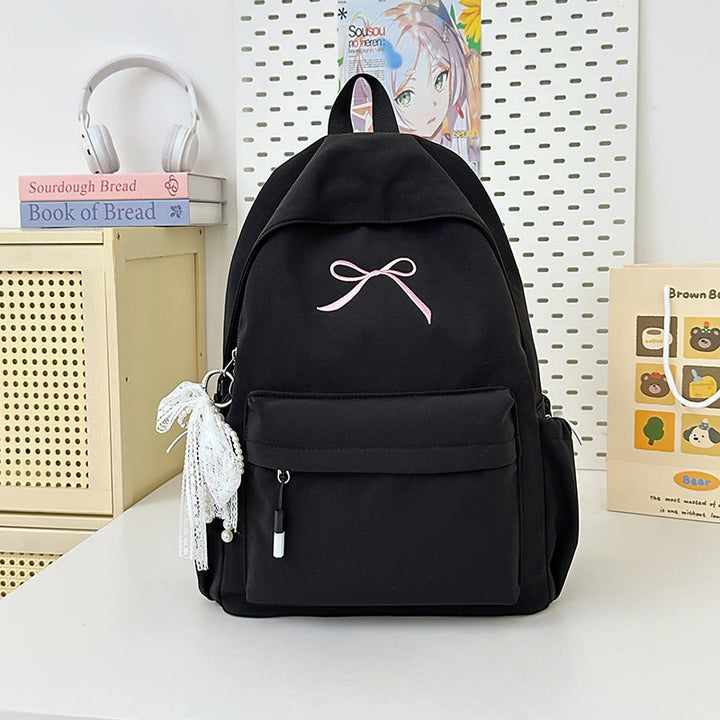 Chic women's fashion backpack with minimalist design & bow detail. Lightweight student bag for daily essentials.