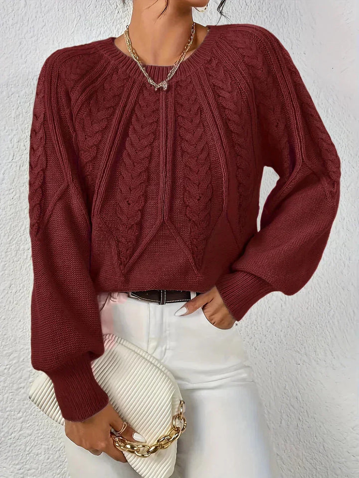 Chic women's cable knit sweater with cozy texture and modern voluminous sleeves. Versatile long sleeve top.