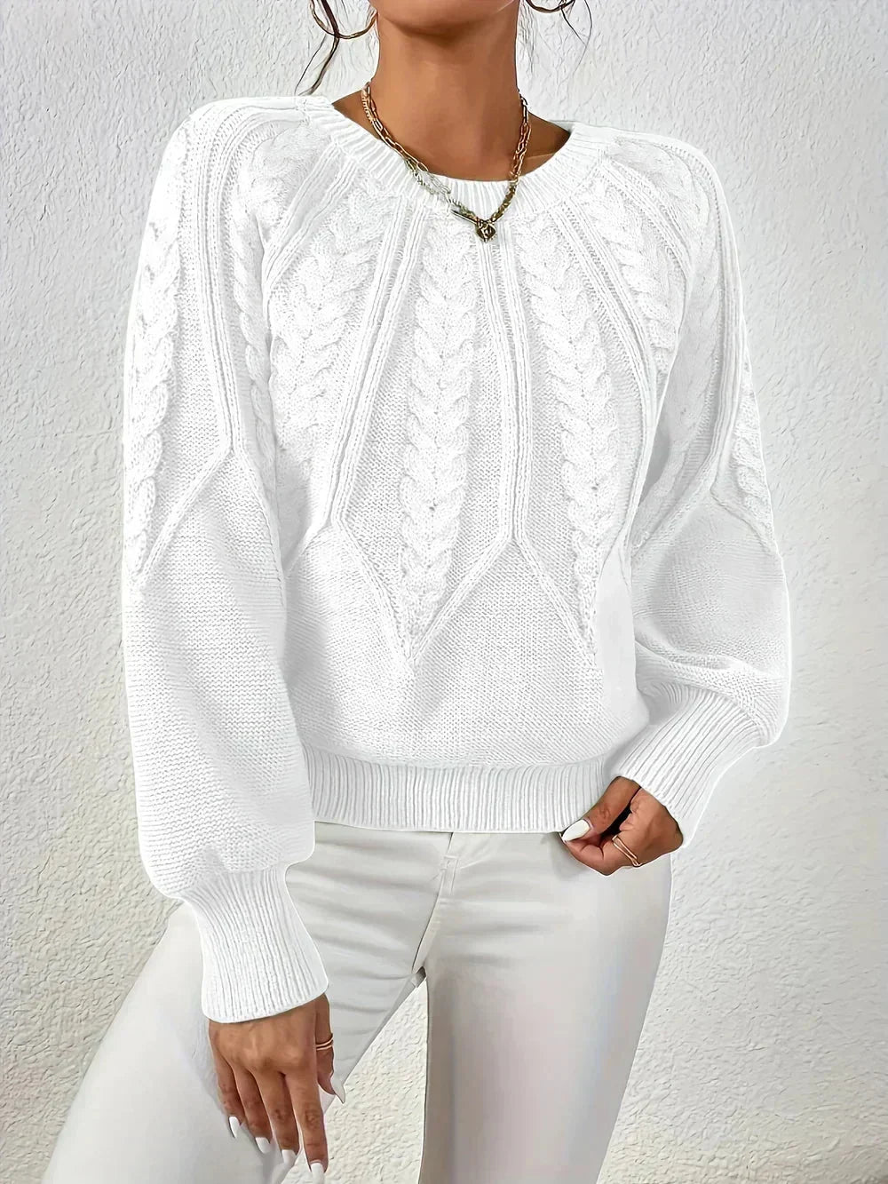 Comfortable women's knit sweater featuring a classic cable pattern, crew neck, and chic voluminous sleeves.