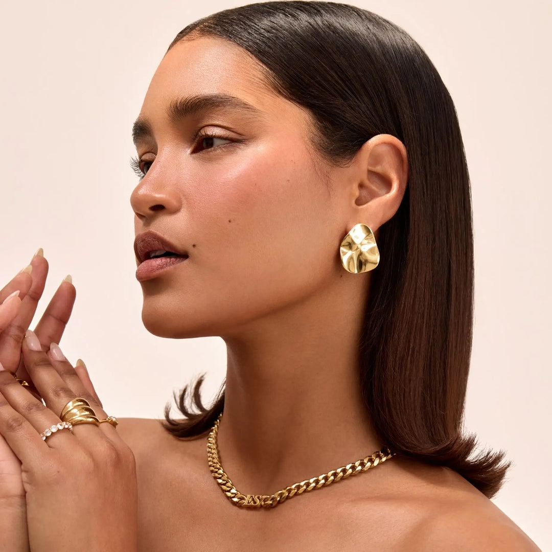 Gold plated modern geometric stud earrings for women, a sculpted statement jewelry piece.